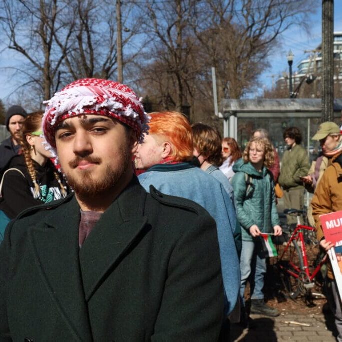 Spencer Allen stands in Victoria Park before the protest on Saturday, March 2, 2024. Allen is a Palestinian and Indigenous organizer who spoke out at the march against businesses he said support the genocide against Palestine. 