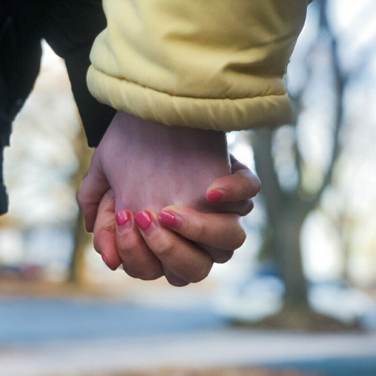 In this image: Close-up of holding hands.