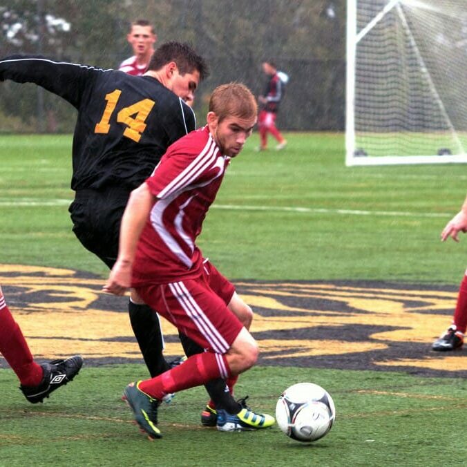 Dal's James Nearing tries to get a foot on the ball as his opponent breaks for it. (Chris Parent photo)