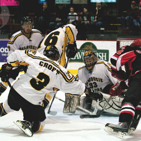 Varsity Reds forward Stefan Salituro   faces fierce opposition from the Tigers as he crashes the net. Photo by Andrew Meade via the Brunswickan