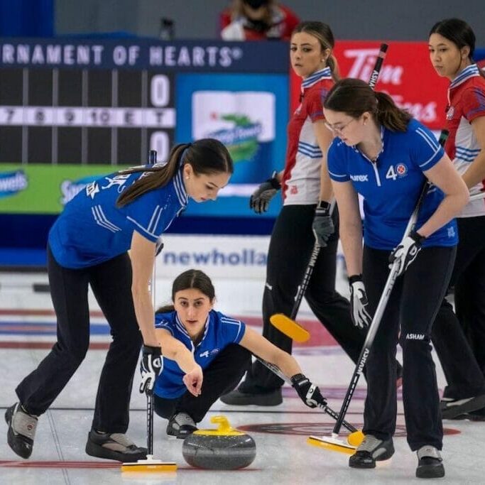 Karlee Burgess and Lauren Lenentine prepare to sweep a stone thrown by teammate Emily Zacharias. Team Zacharias picked up three wins in its first Scotties competition. (Photo submitted by Karlee Burgess) 