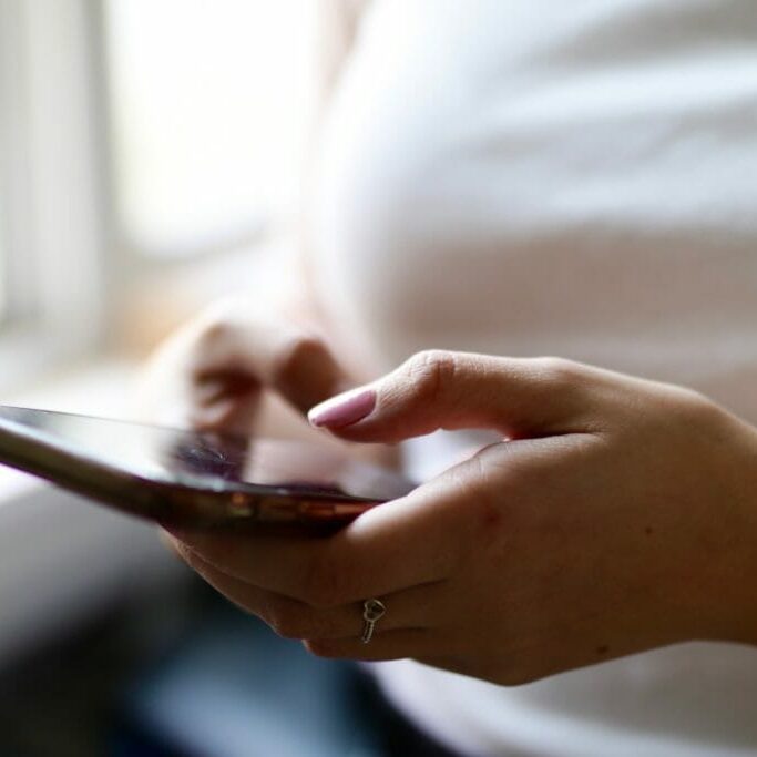 In this image: A person using a cellphone.