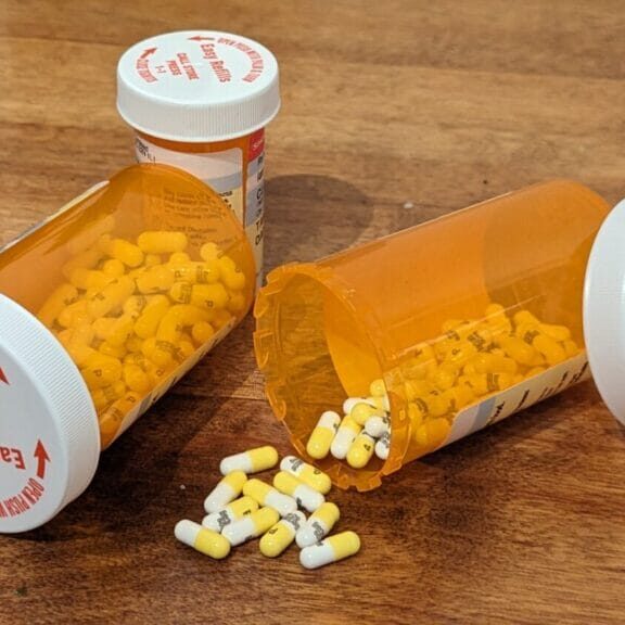 Prescribing equity _ alex robben Bottles of pills tipped over, some have spilled.