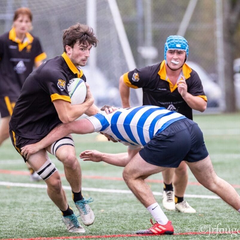 The Dalhousie rugby player tries to evade the StFX player’s reach as the X-Man goes in for a tackle.