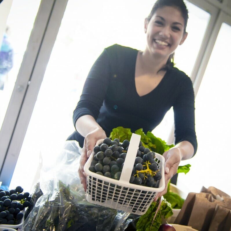 A volunteer sells fruits at one of the market's three booths (photo by Chris Parent)
