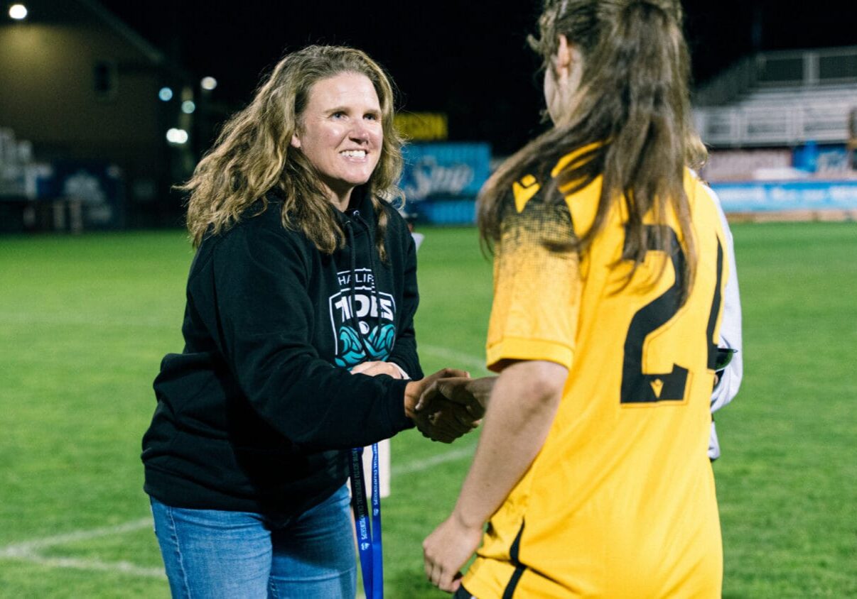 Halifax Tides CEO Courtney Sherlock shakes the hand of a young women’s soccer player. 
