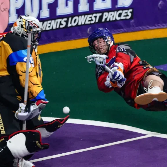 Halifax Thunderbird Jason Knox falls while throwing a shot against the opposing goalie. Image by NLL.