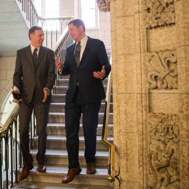 In this image: Maxime Bernier and Andrew Scheer walk down a staircase at Parliament Hill.