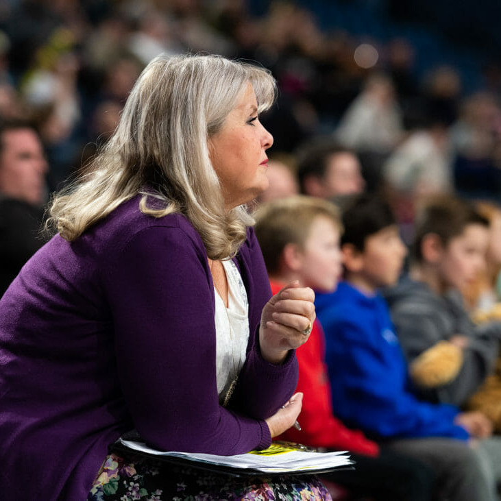 In this image: Andrea Plato watching a basketball game.