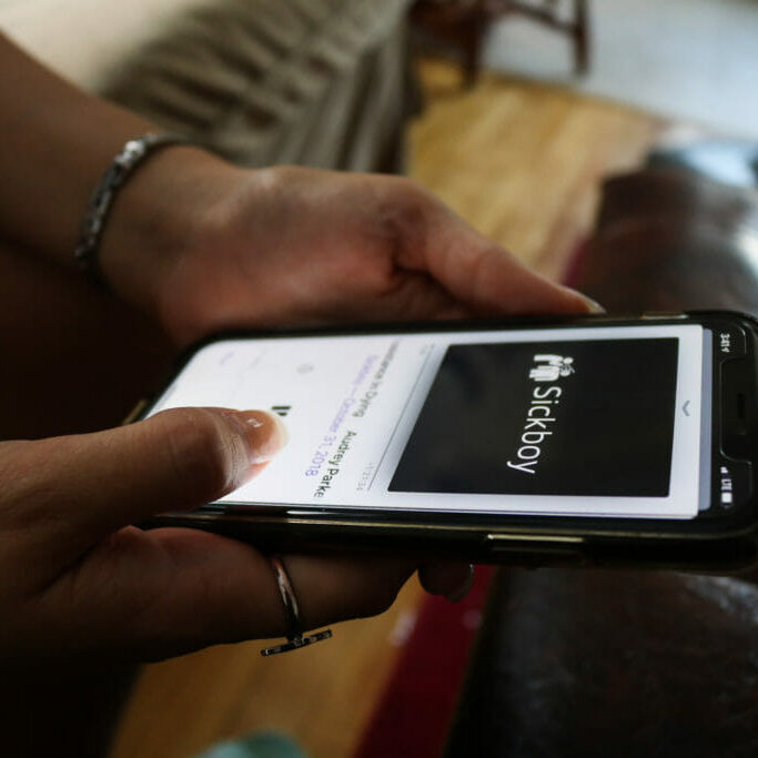 In this image: Someone holding a phone with the Sickboy podcast playing.