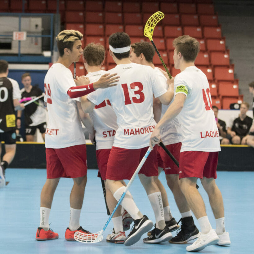 In this image: Team Canada from Men's World Floorball Championships huddles together.