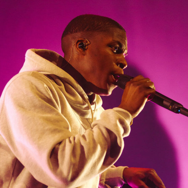 In this image: Close up of Daniel Caesar on stage.
