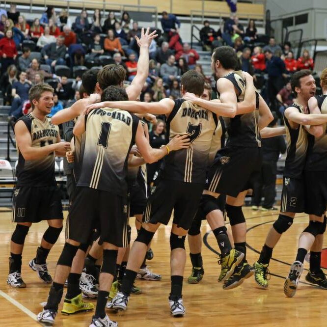 Jonathan MacDonald (1) and Matthew Donovan (7) join their Tigers teammates in celebrating an improbable win. (Photo by Fran Harris via the University of New Brunswick)