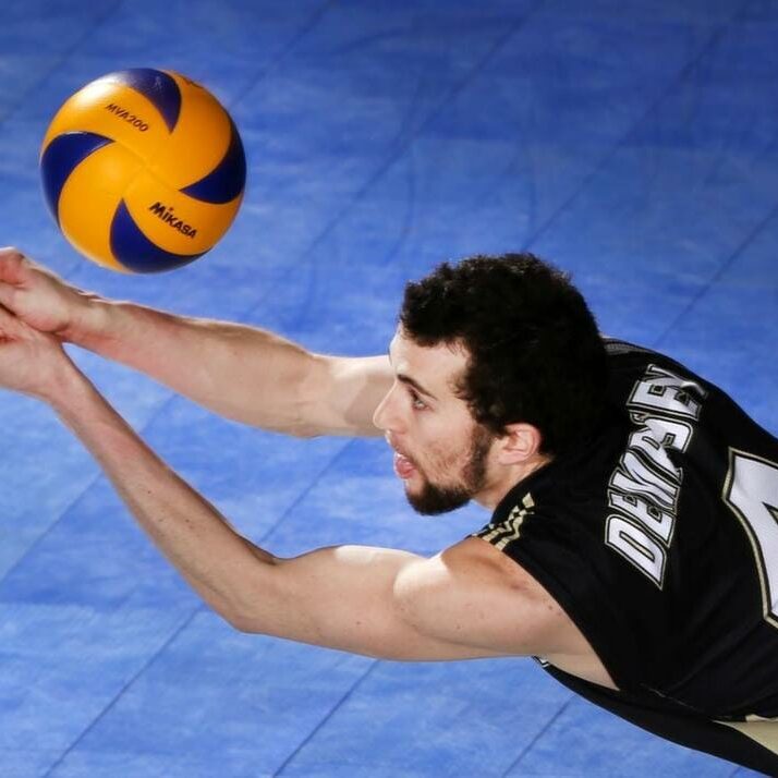 Alex Dempsey (4) lunges for the dig in CIS championship play. (Photo by David Moll via Calgary [CIS])