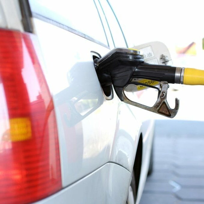 In this image: a car being pumped with gas.