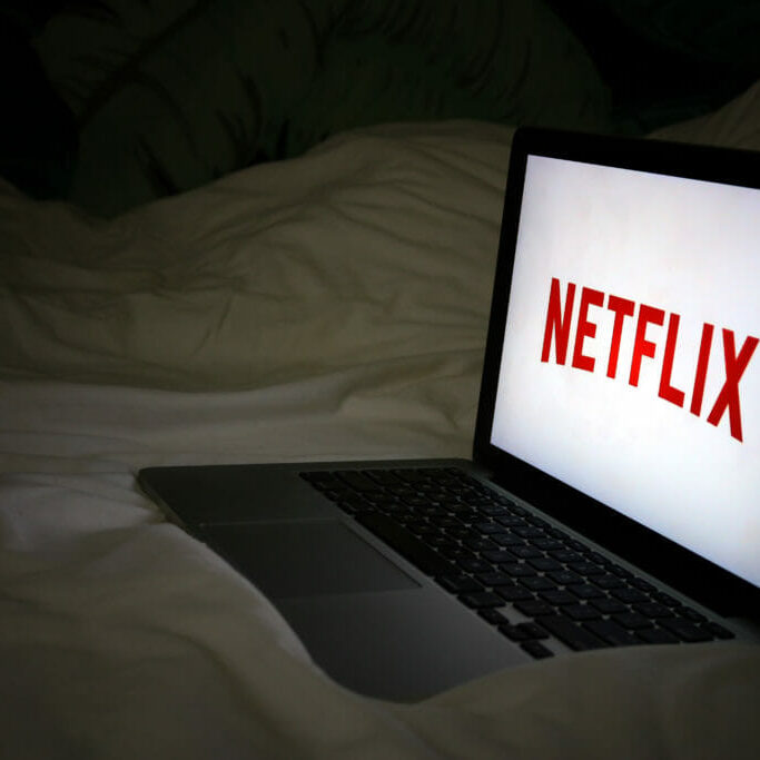selfcare_MelanieKenny In this image: A laptop with Netflix playing on a bed.
