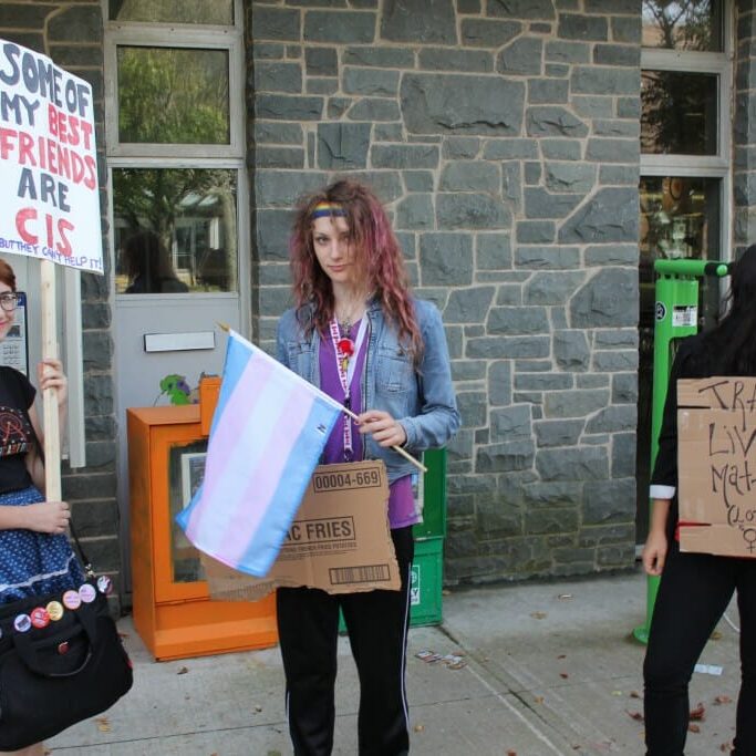 Participants in the rally for trans rights hold signs in front of Dal's Student Union Building. (Photo by Natasha MacDonald-Dupuis)